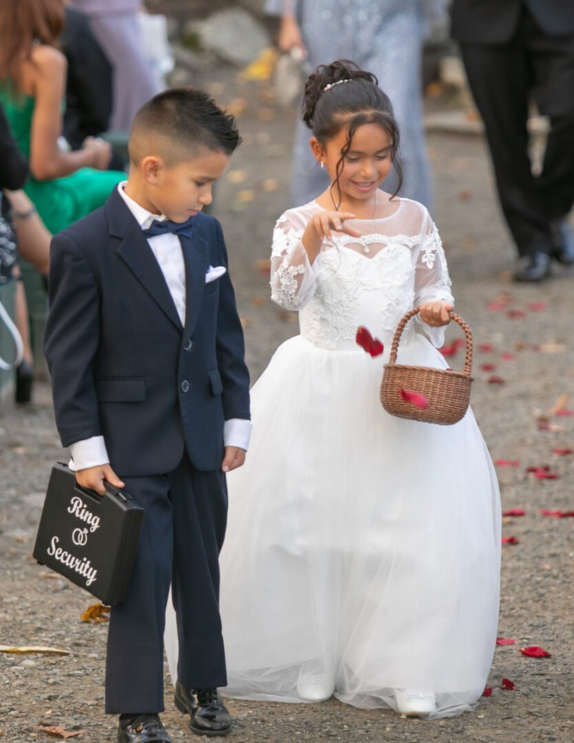 A young boy and girl in formal wear standing next to each other.