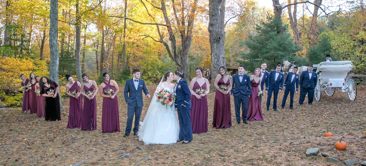 A group of people standing around each other in the woods.