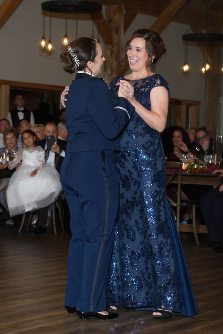 Two women in formal wear dancing at a party.