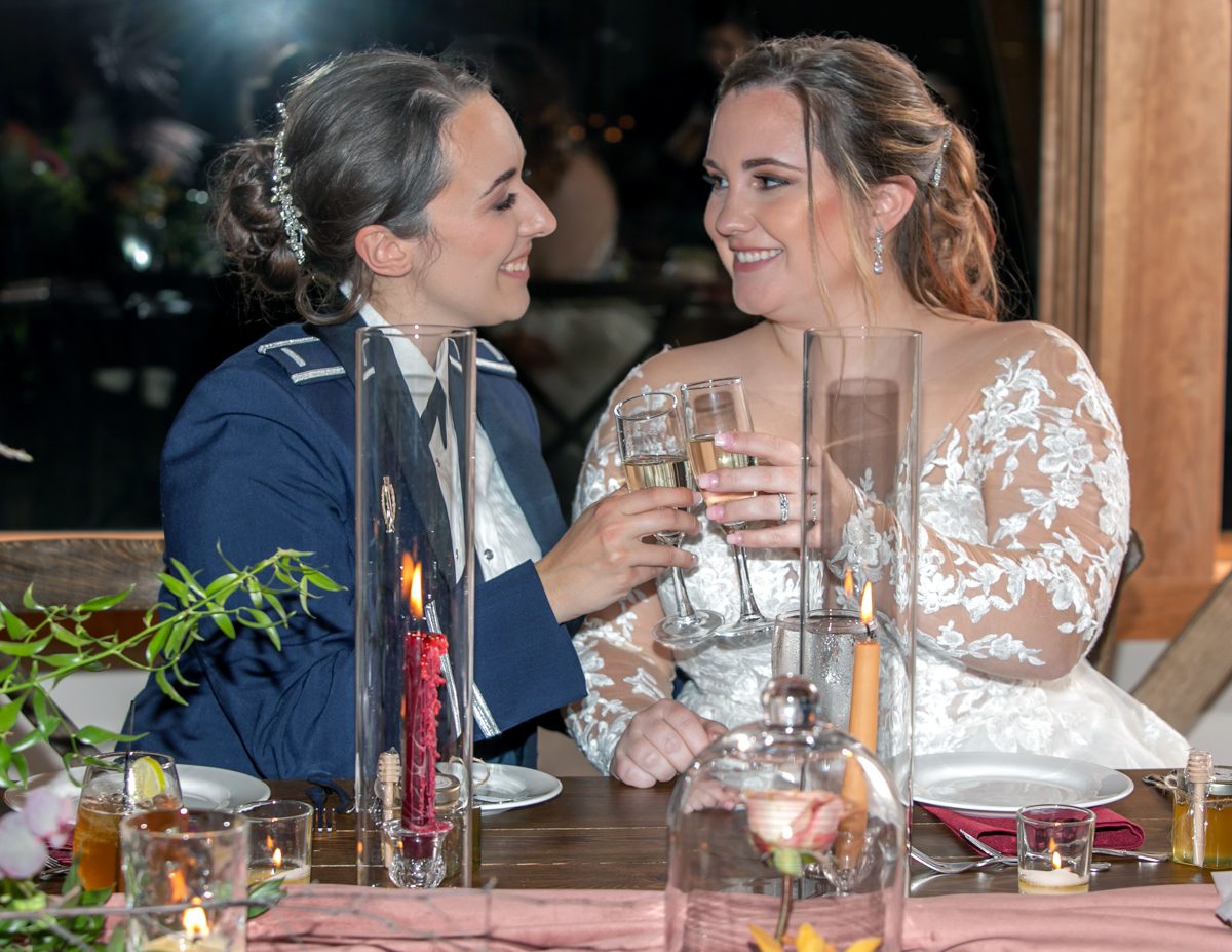 Two women sitting at a table with wine glasses.